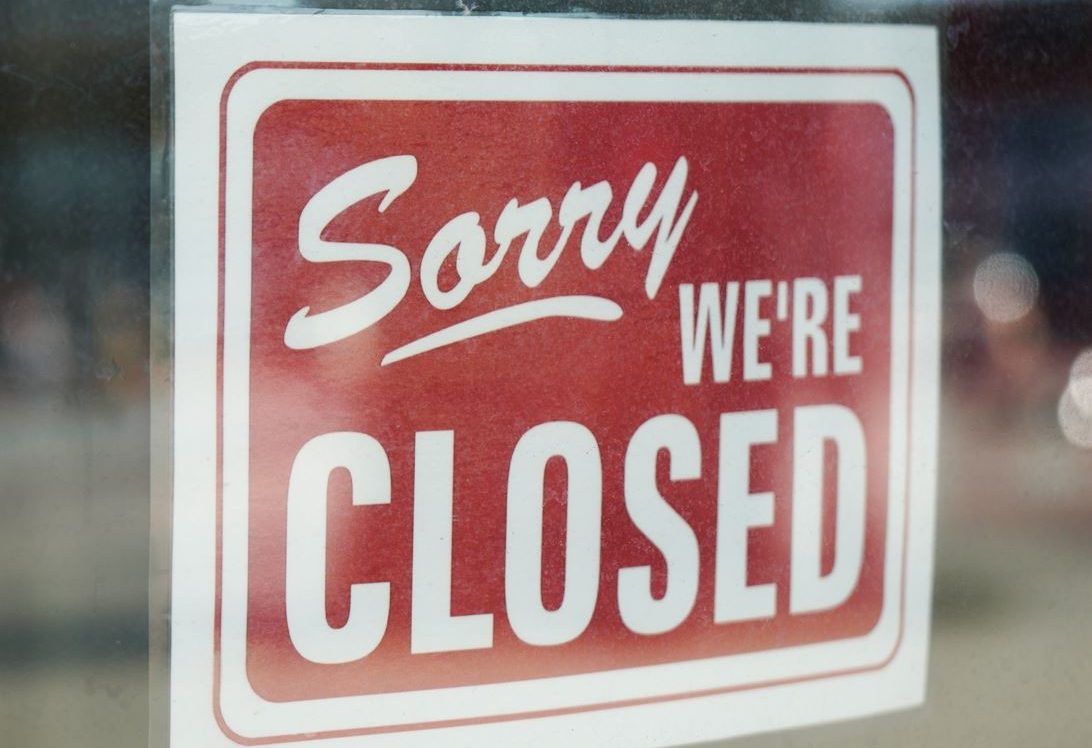 Sorry We'Re Closed Sign Hanging In A Storefront Window